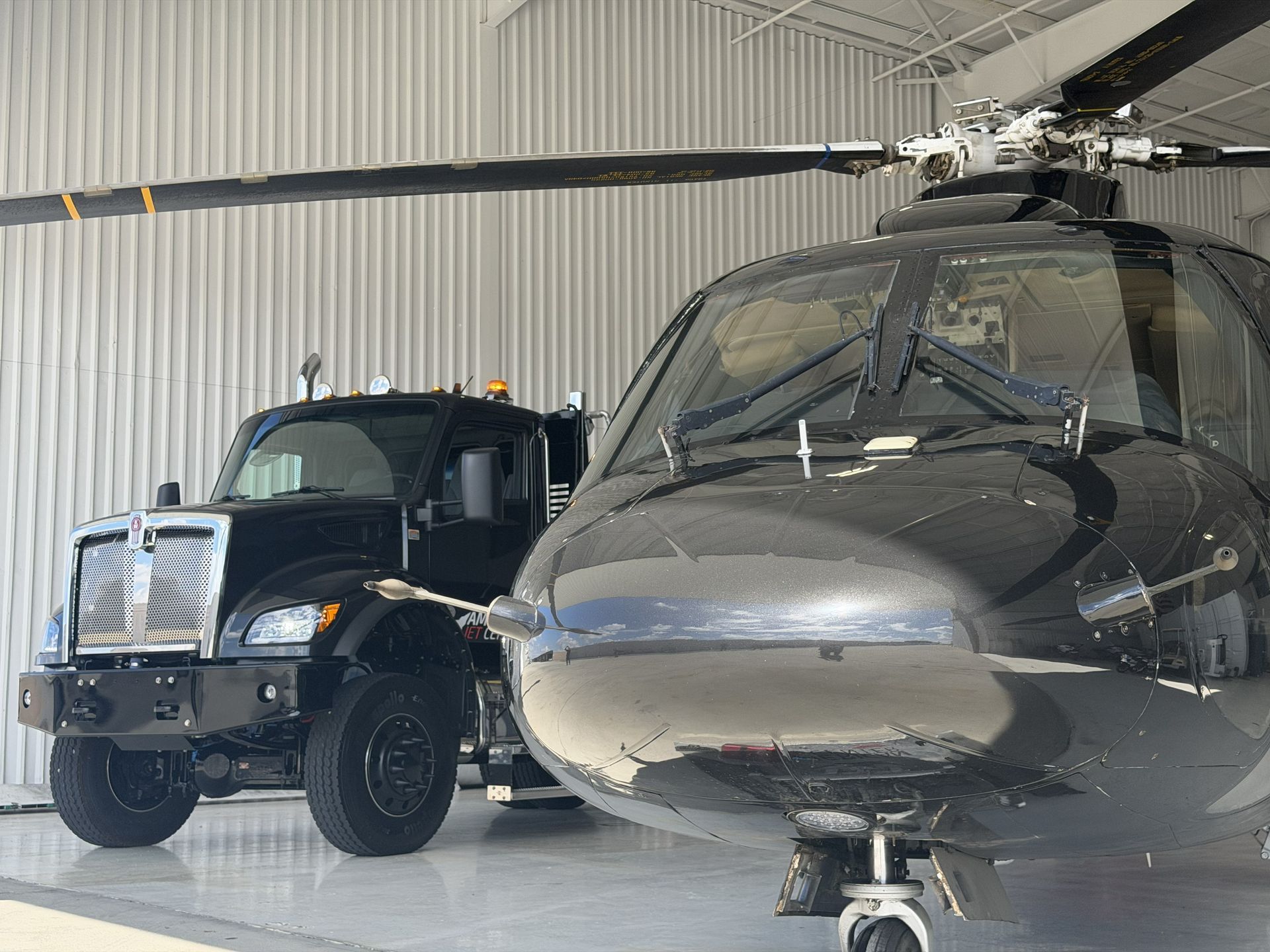 Helicopter and work truck parked inside a hangar | American Jet Center